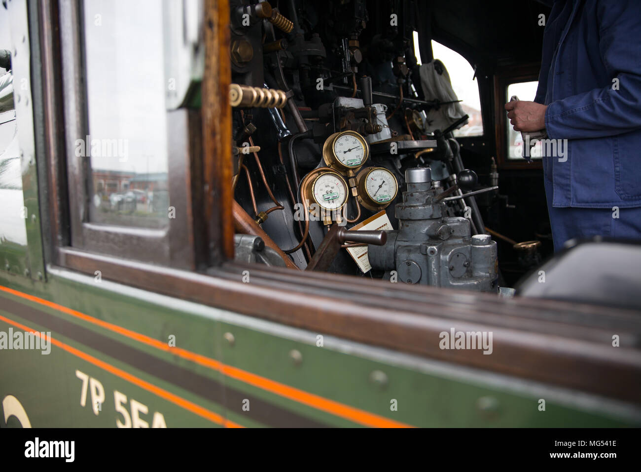 Close up of steam train driver isolated in engine cab on footplate of vintage UK steam locomotive at controls. Steam trains UK. Stock Photo