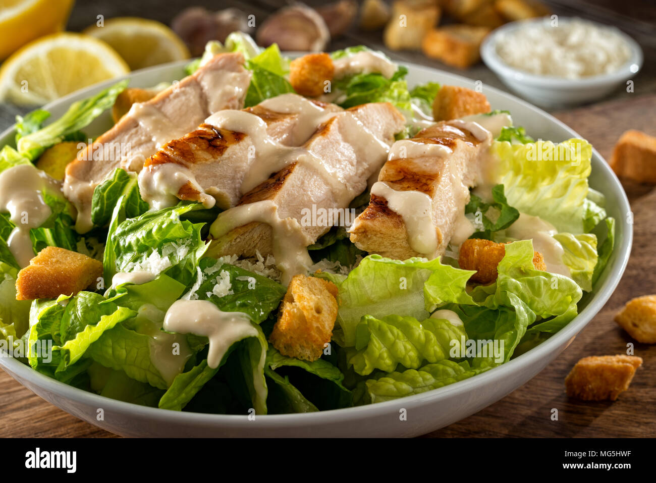 A delicious chicken caesar salad with parmesan cheese, dressing and croutons. Stock Photo