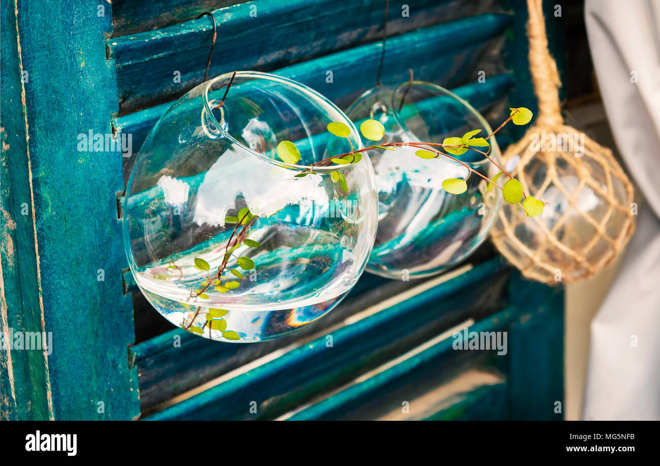 Glass objects on teal couloured wooden background. Decorative garden