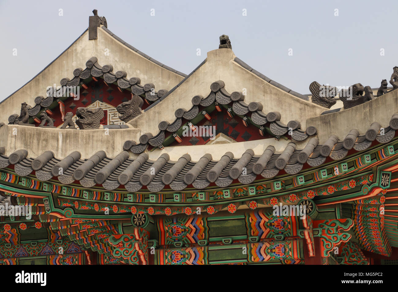 Curving roofs of buildings in Changdeokgung Palace Complex in Seoul, South Korea, with tiling, colorful painted wooden eves and ceramic beasts. Stock Photo