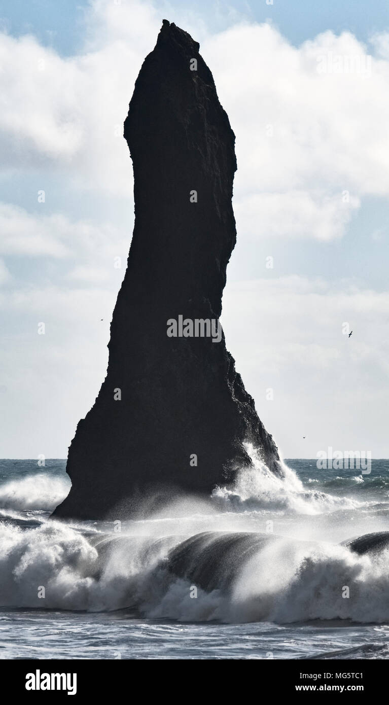 Reynisfjara, South Iceland. The beach is a famous tourist attraction. One of the Reynisdrangar sea stacks, or basalt pillars Stock Photo