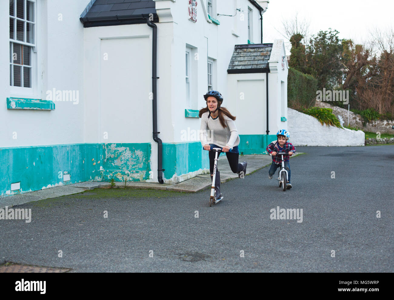 A mother racing with her son on his bike Stock Photo