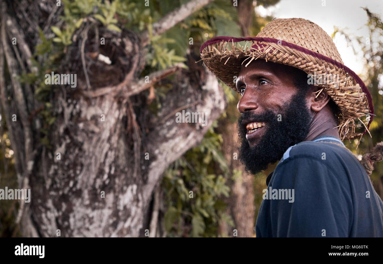 Papua New Guinea - November 12, 2010:  A smiling man with a beard is wearing a strawhat. Stock Photo