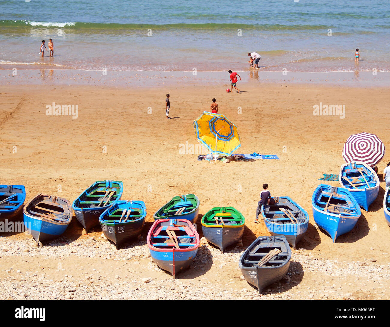 Fishing boats and parasols on The beach at Taghzoute on Morocco's Atlantic coast Stock Photo