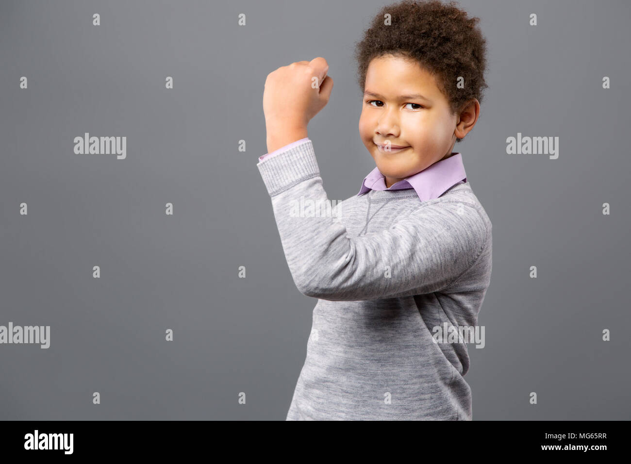 Nice cute boy showing his muscles Stock Photo