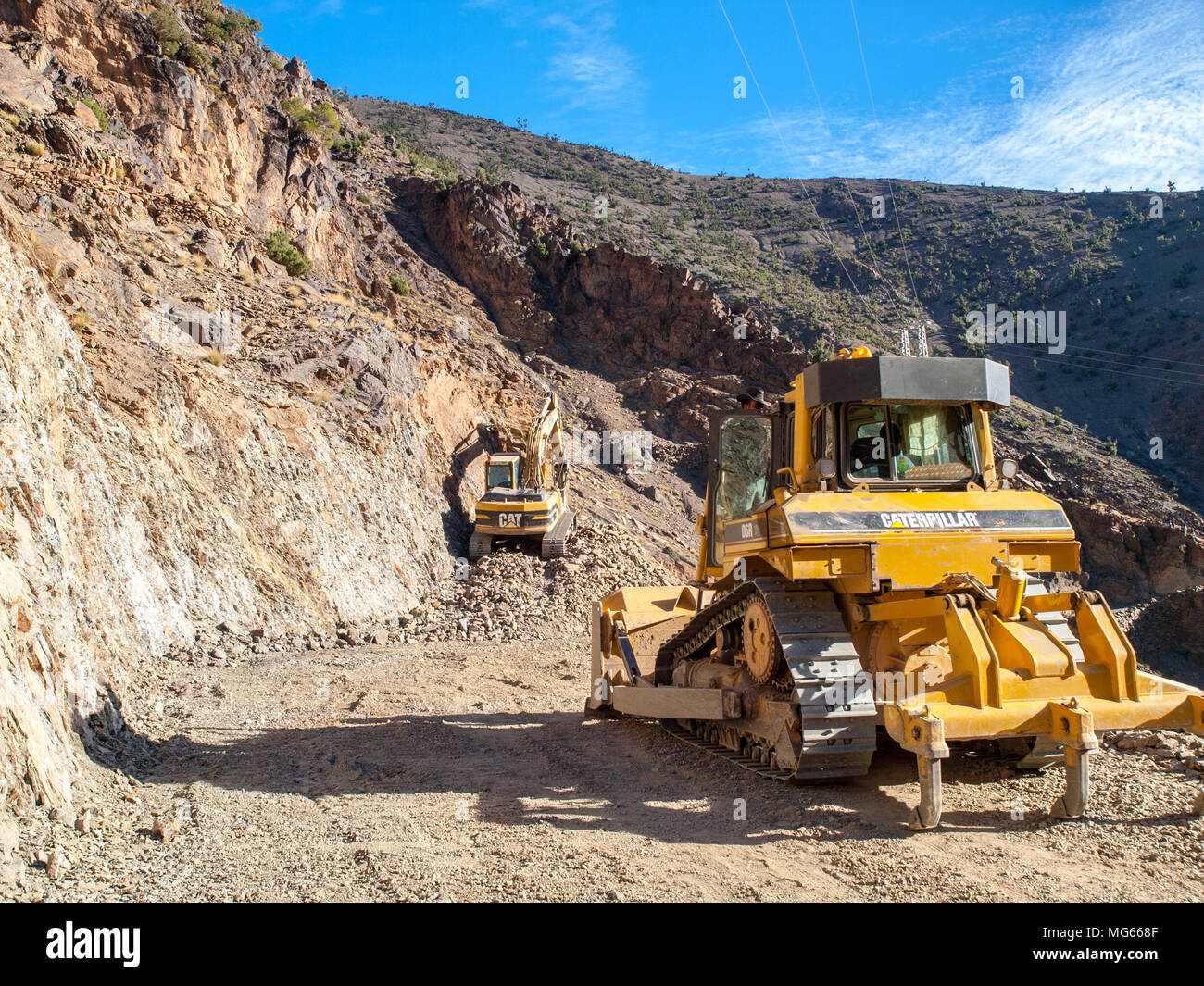 Road building machinery digging a new road through the Atlas mountains, morocco Stock Photo