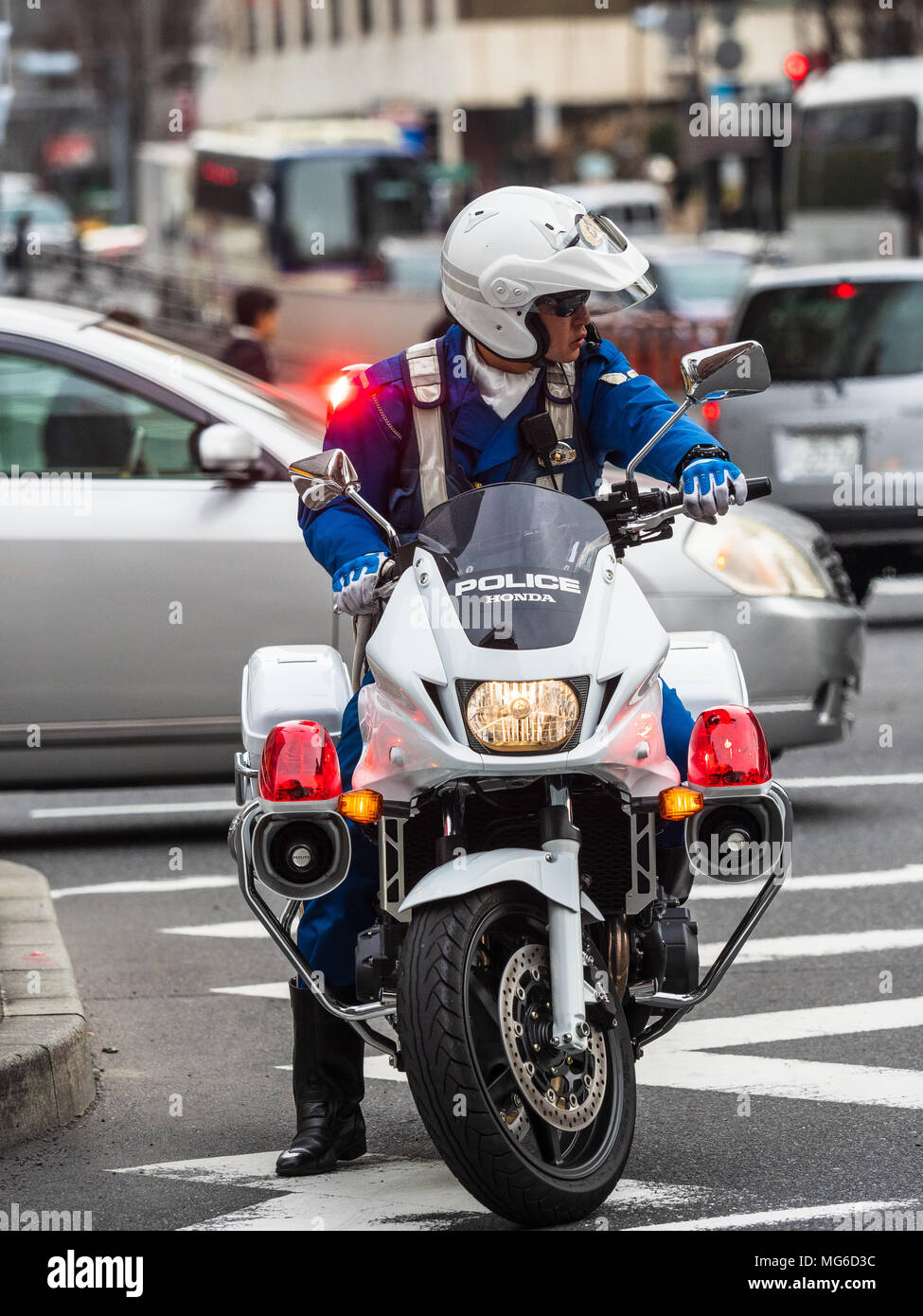 Tokyo Police Motorcyclist waits at a junction in Tokyo. Japanese Motorcycle Police Officer. Stock Photo