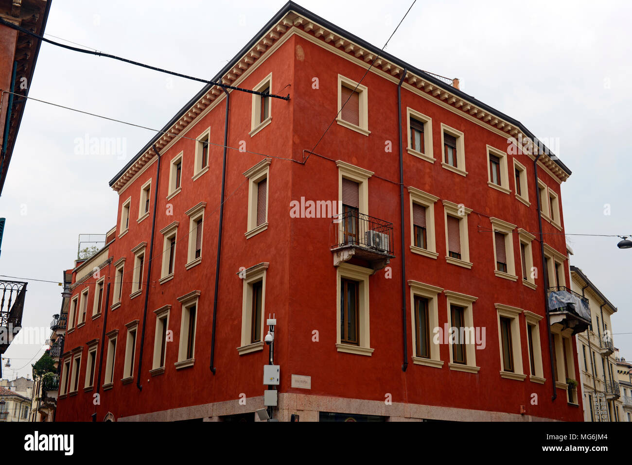 Red building on street corner in Verona, Italy Stock Photo