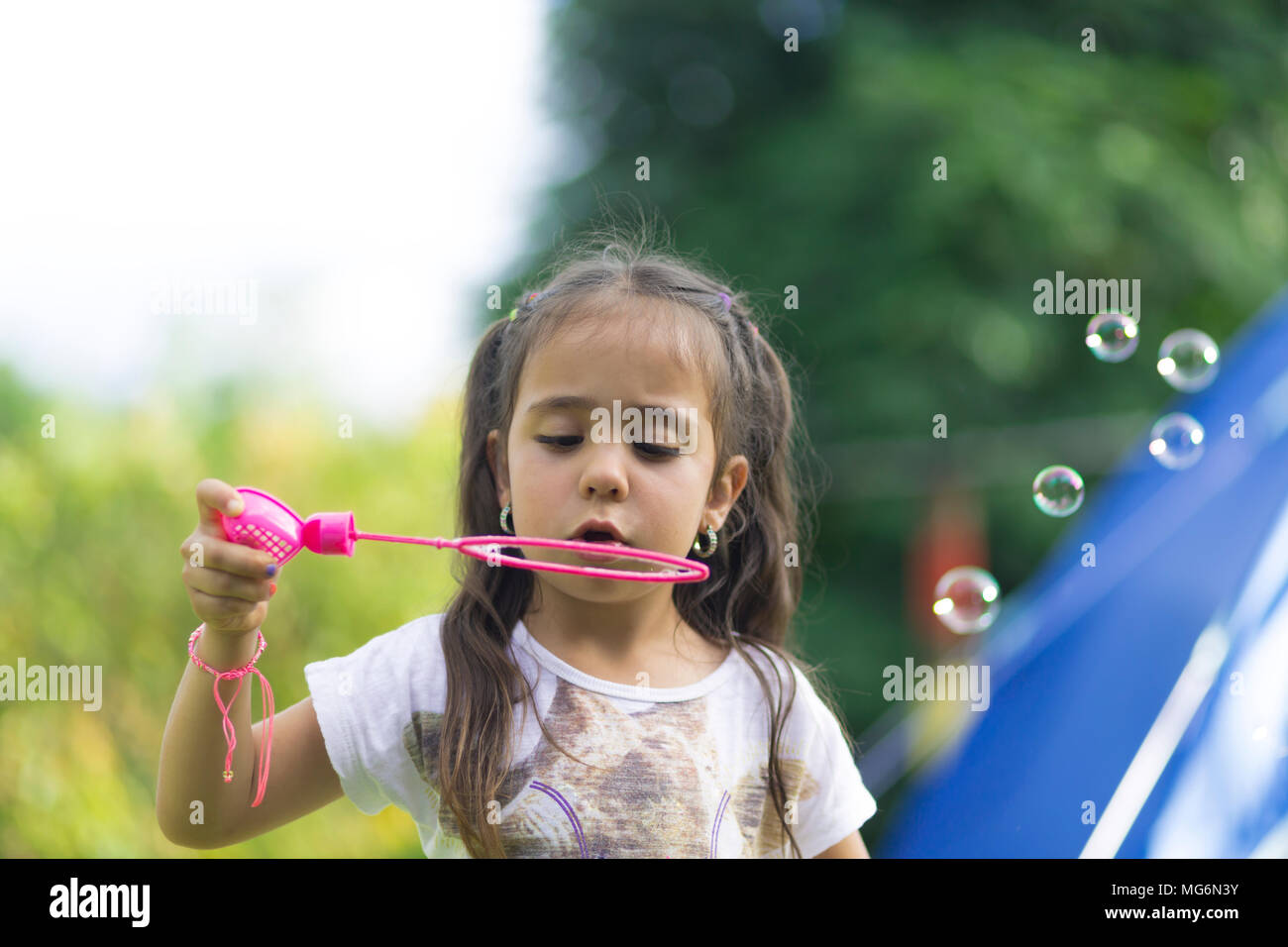 Happy Girl Playing with Soap Bubbles Stock Photo - Alamy