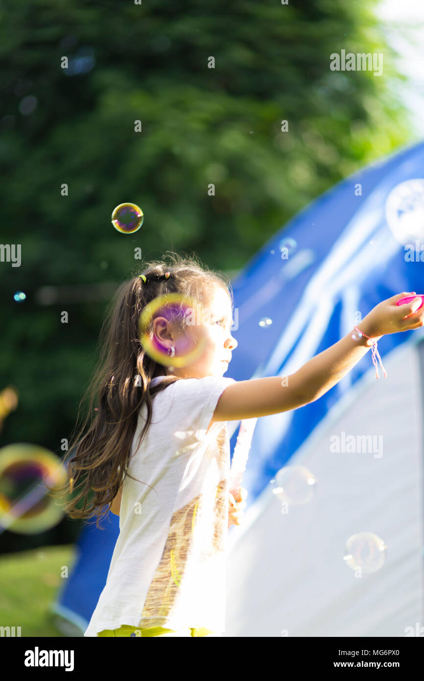 Happy Girl Playing with Soap Bubbles Stock Photo - Alamy
