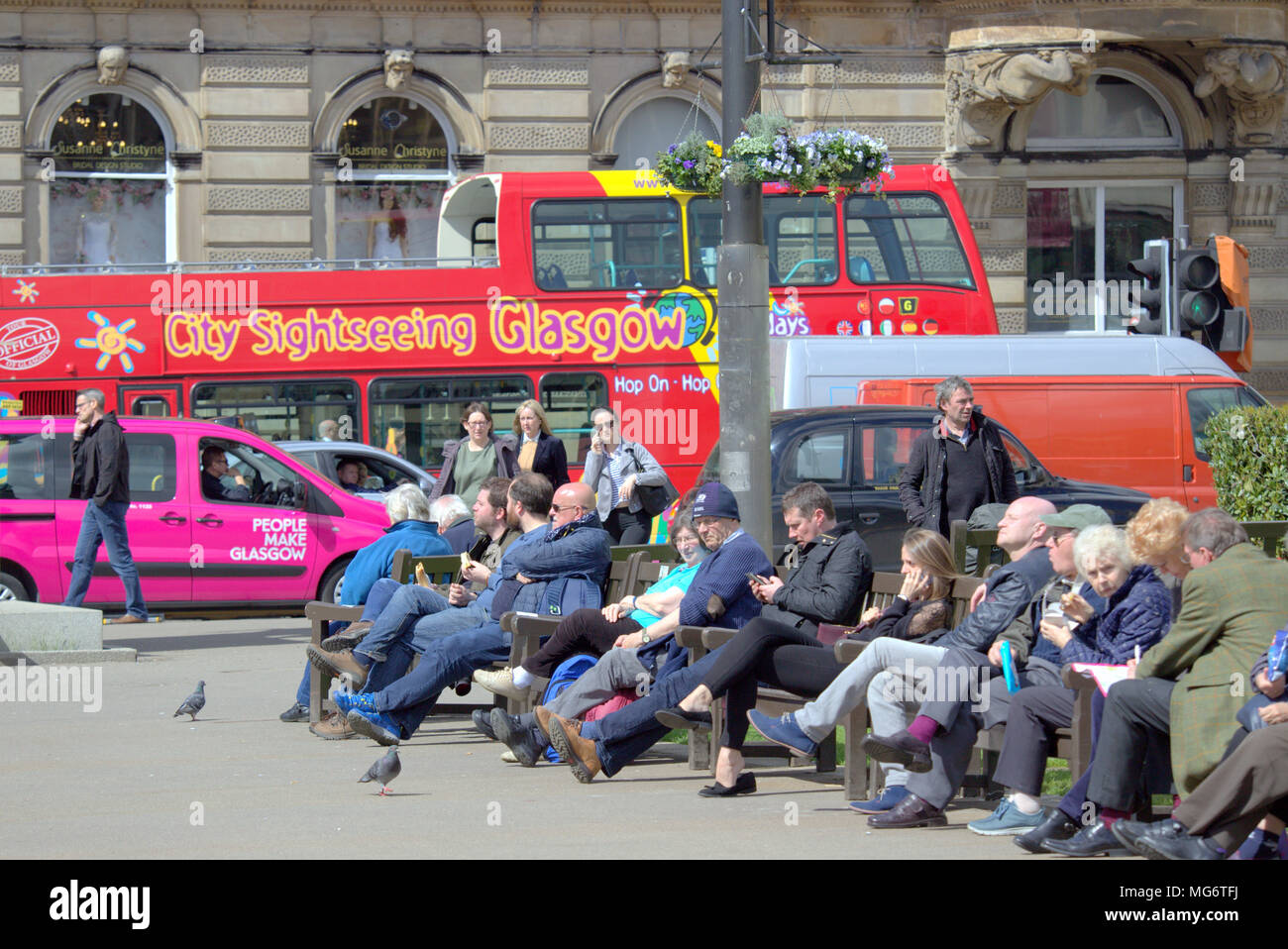 Glasgow, Scotland, UK 27th April. UK Weather: city sightseeing Glasgow bus with tourists Sunshine comes to the city as the locals and tourists enjoy the hot weather in George Square at the heart of the city. Gerard Ferry/Alamy news Stock Photo