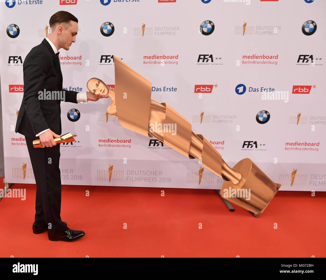 27 April 2018, Germany, Berlin: Franz Rogowski showing his prize for 'best male role' for the film 'In den Gaengen' at the 68th award ceremony of the German film prize 'Lola'. Photo: Jens Kalaene/dpa-Zentralbild/dpa Stock Photo