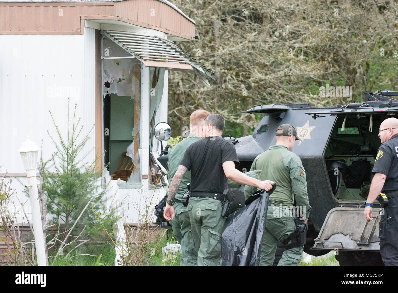 Shelton, Washington, USA, 27 April 2018.  Mason County Sheriff respond to the scene where a man stabbed a process server.  This was taken after the man was arrested and taken to the hospital witha dog bite wound.  It appears that police rammed the trailer with their SWAT vehicle.  Hidden Haven Mobile Home park scene of stand off today in Mason County. (Shawna Whelan) Credit: Shawna Whelan/Alamy Live News Stock Photo