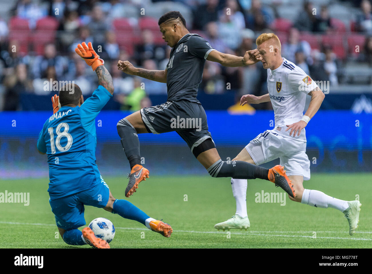 Vancouver, Canada. 27 April 2018. Anthony Blondell (9) of Vancouver Whitecaps (center), trying to get past Goalkeeper Nick Rimando (18) of Real Salt Lake.  Vancouver Whitecaps vs Real Salt Lake BC Place. Vancouver wins 2-0 © Gerry Rousseau/Alamy Live News Stock Photo