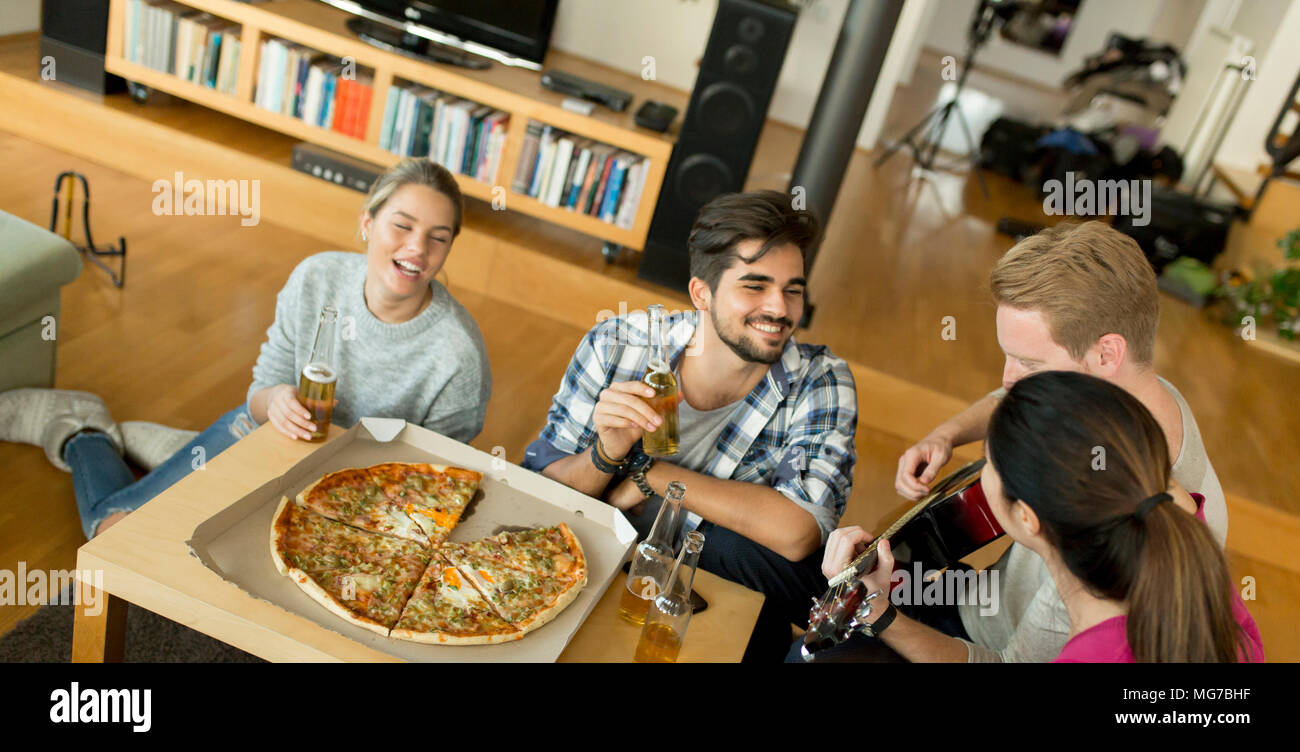 Group Of Young People Having Pizza Party In The Room Stock
