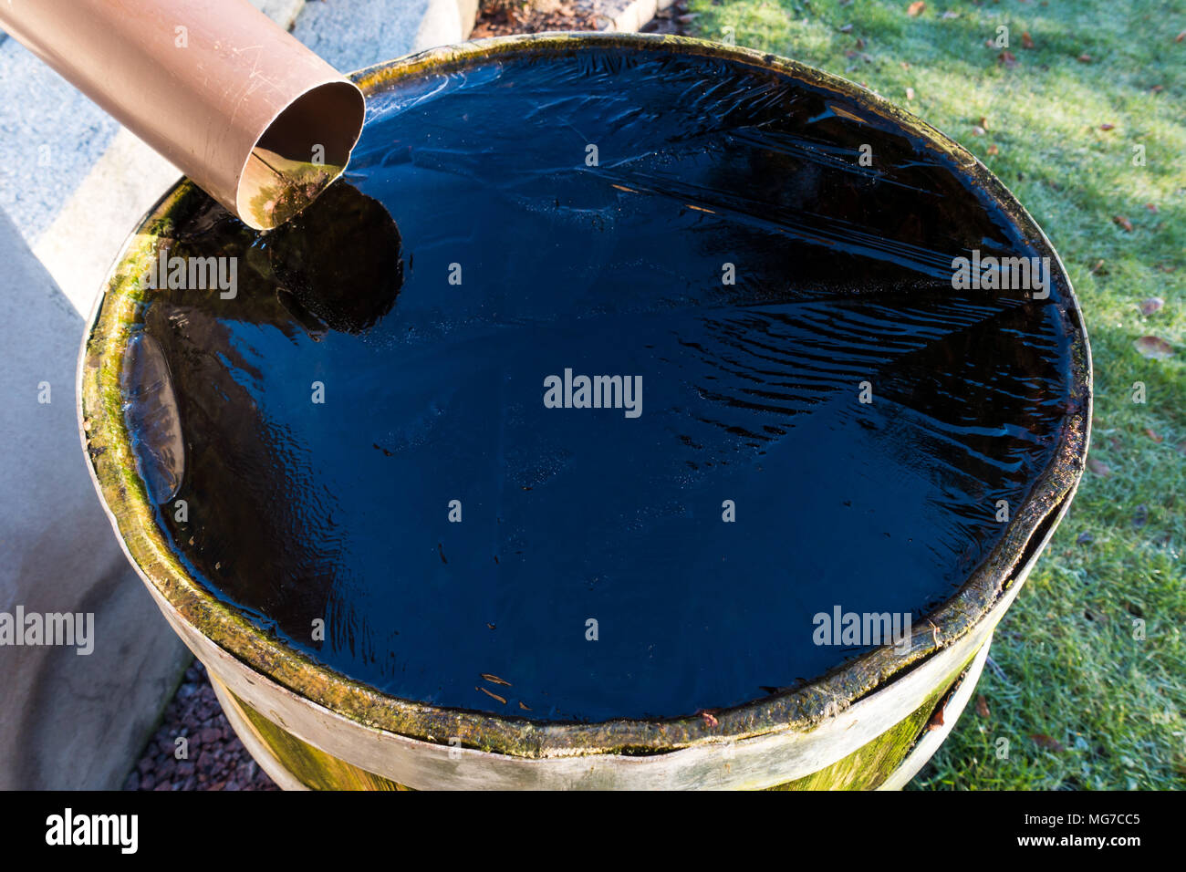A barrel full of water and frozen surface Stock Photo