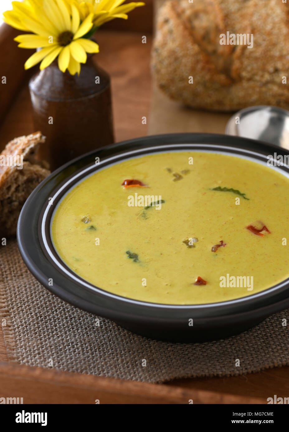 spicy cream soup place on a wooden tray, showing bread in the background. room for text and copy space Stock Photo