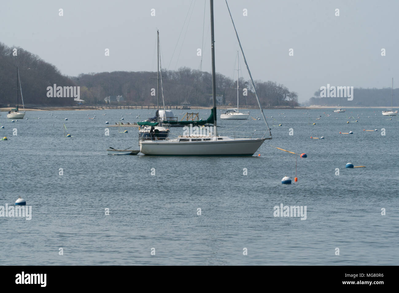 Sailboat mooring docks in coast town harbor water on a summer day Stock Photo