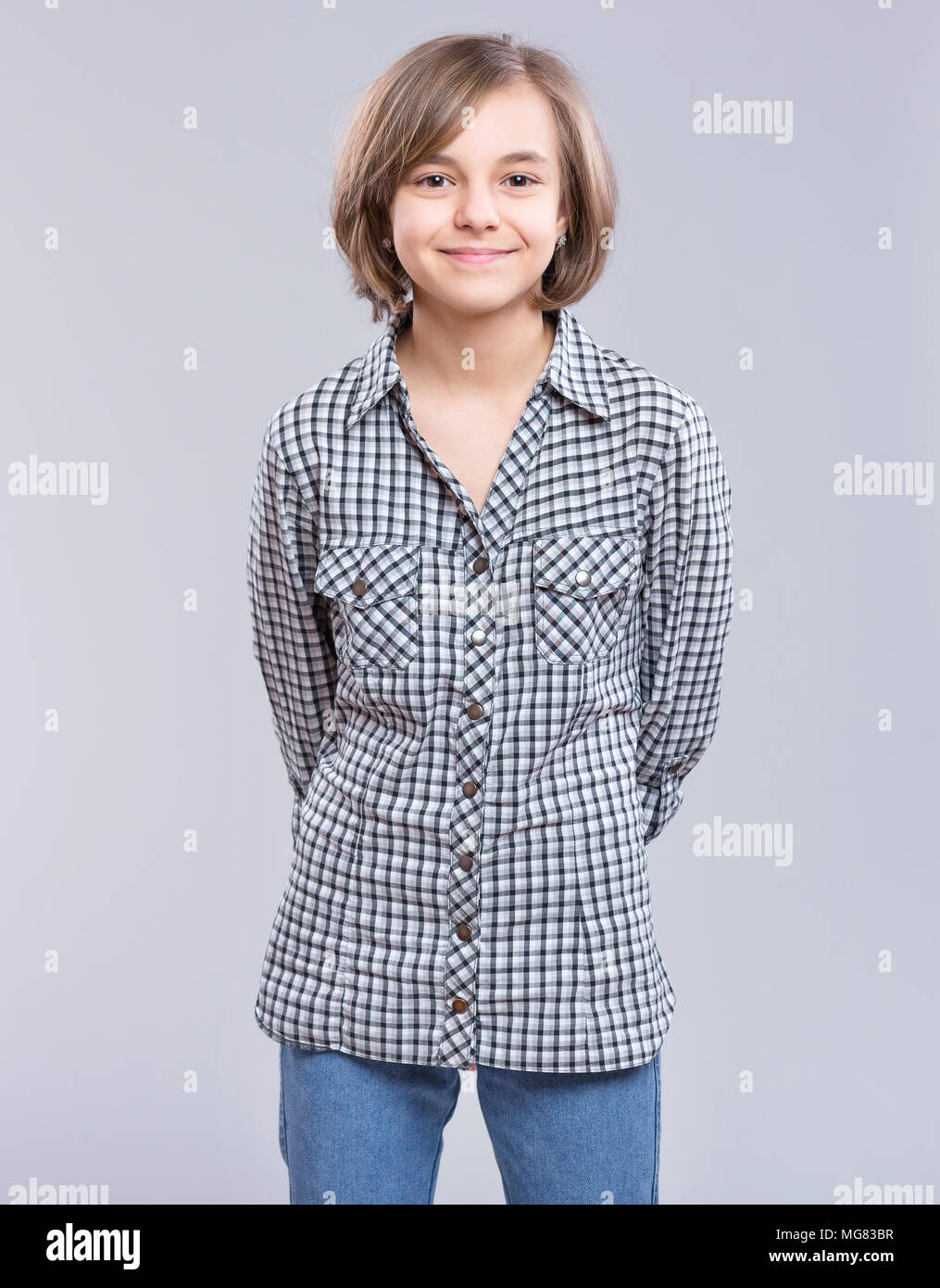 Little girl with her hands behind her back hires stock photography and