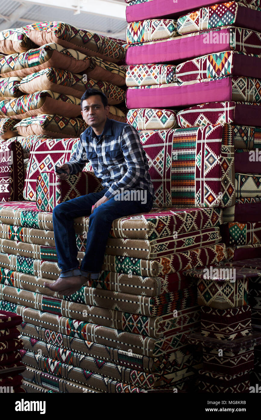 A man selling cushions at a market in Kuwait Stock Photo