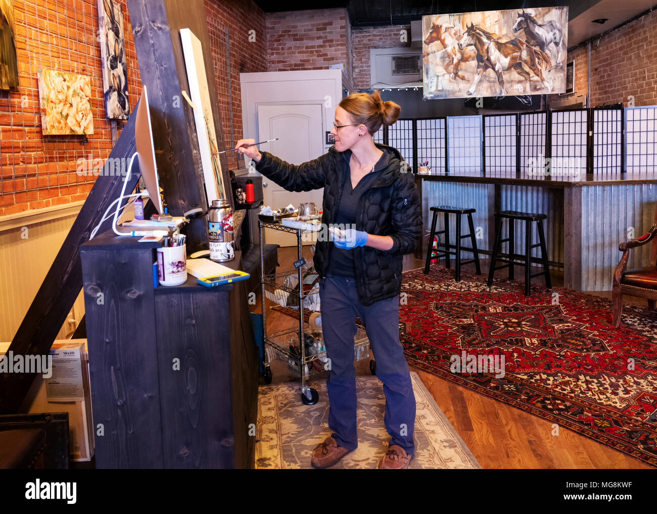 Fine artist Katie Maher creating an oil painting in her gallery; Salida; Colorado; USA Stock Photo