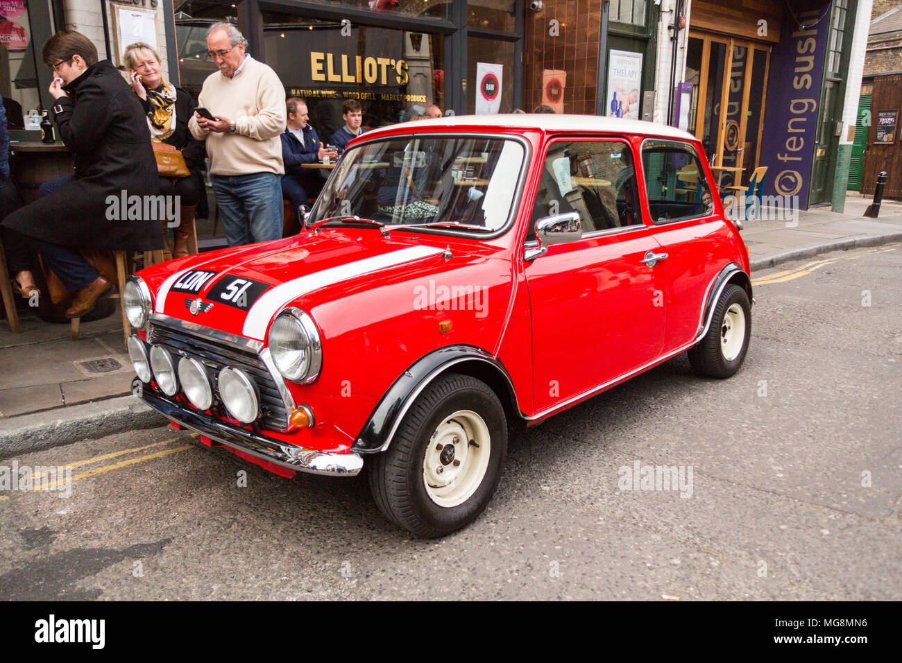 London, United Kingdom - May 2, 2015: A 1951 Mini motor car sits on a street near Borough Market in the heart of London, gleaming and shiny in red. Stock Photo