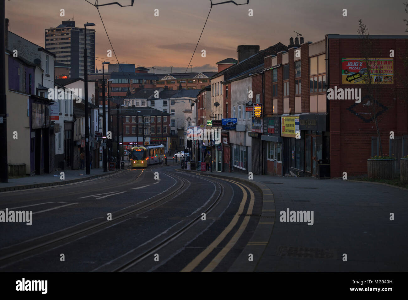 A Manchester metrolink tram climbing Drake street, Rochdale at sunset