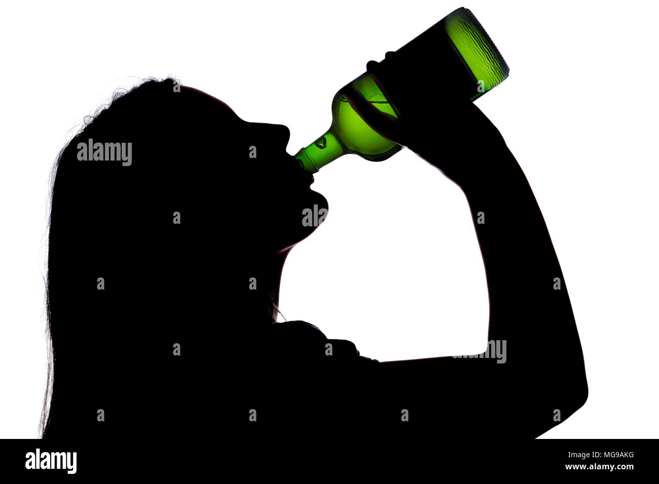 Woman drinking straight from bottle, silhouette. Stock Photo