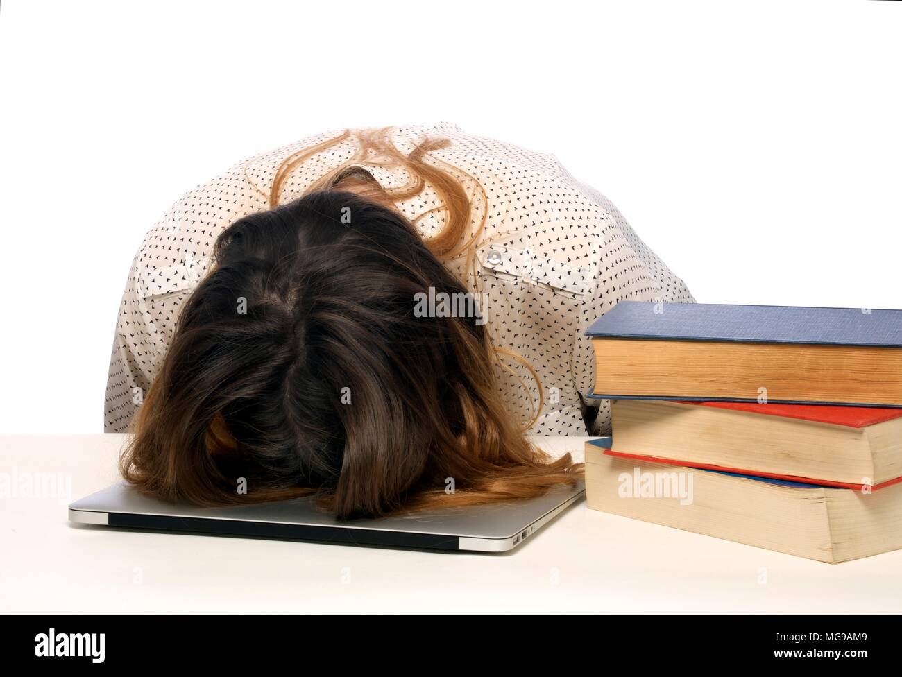 Young woman with head on laptop. Stock Photo