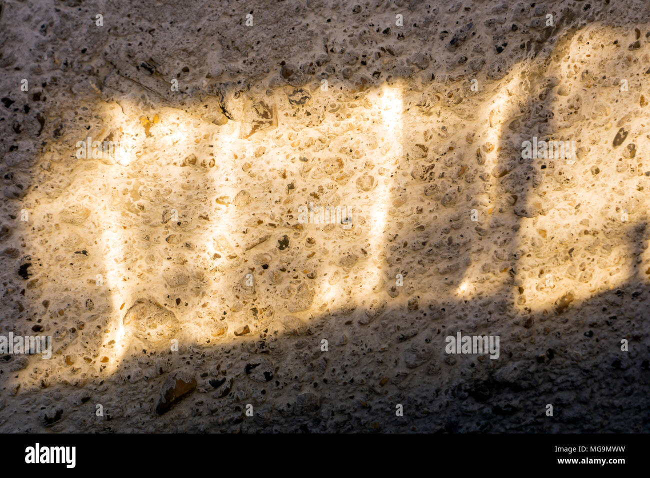 bright sunbeam on a rough concrete wall Stock Photo