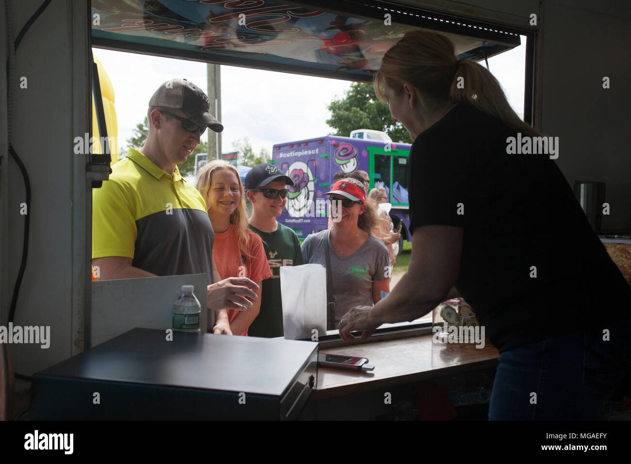 Satisfied customer buying a bag of donuts from a food truck vendor Stock Photo