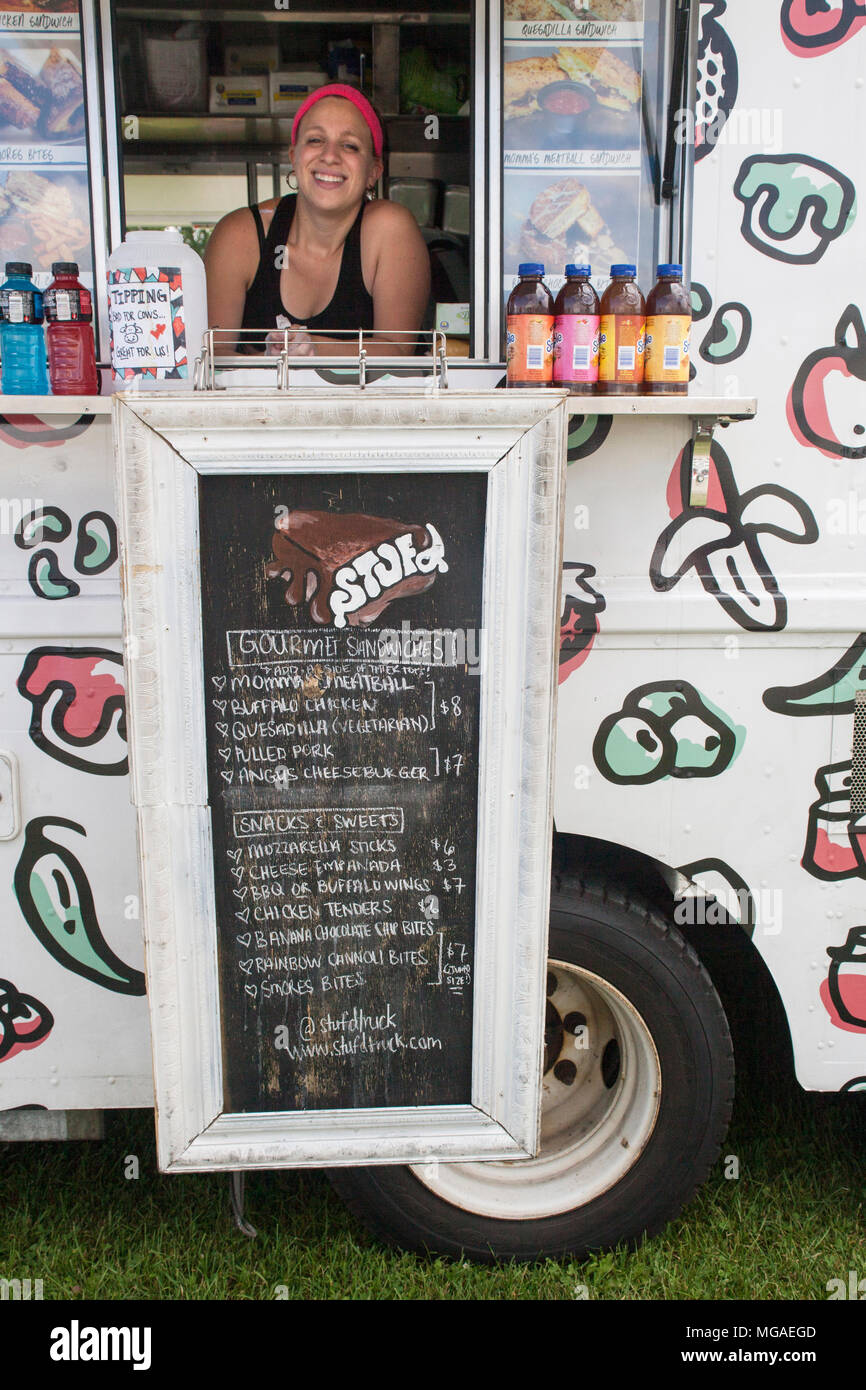 Portrait of a Hispanic female small business owner posing in the window of her sandwich food truck Stock Photo