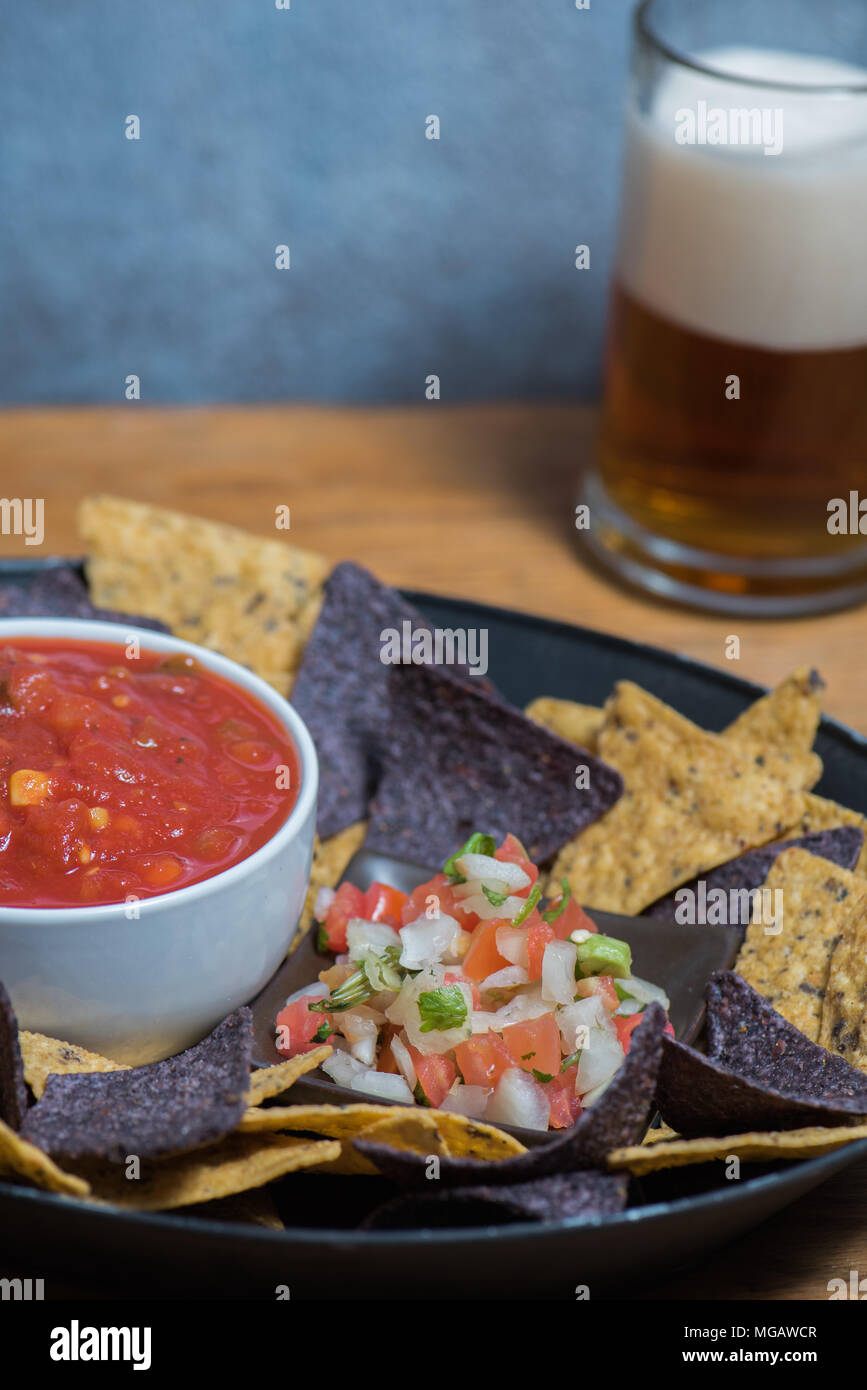 Bowl of salsa with pico de gallo, chips and beer Stock Photo Alamy