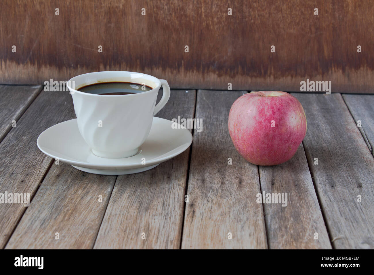 coffee cup and red apple on wood table Stock Photo