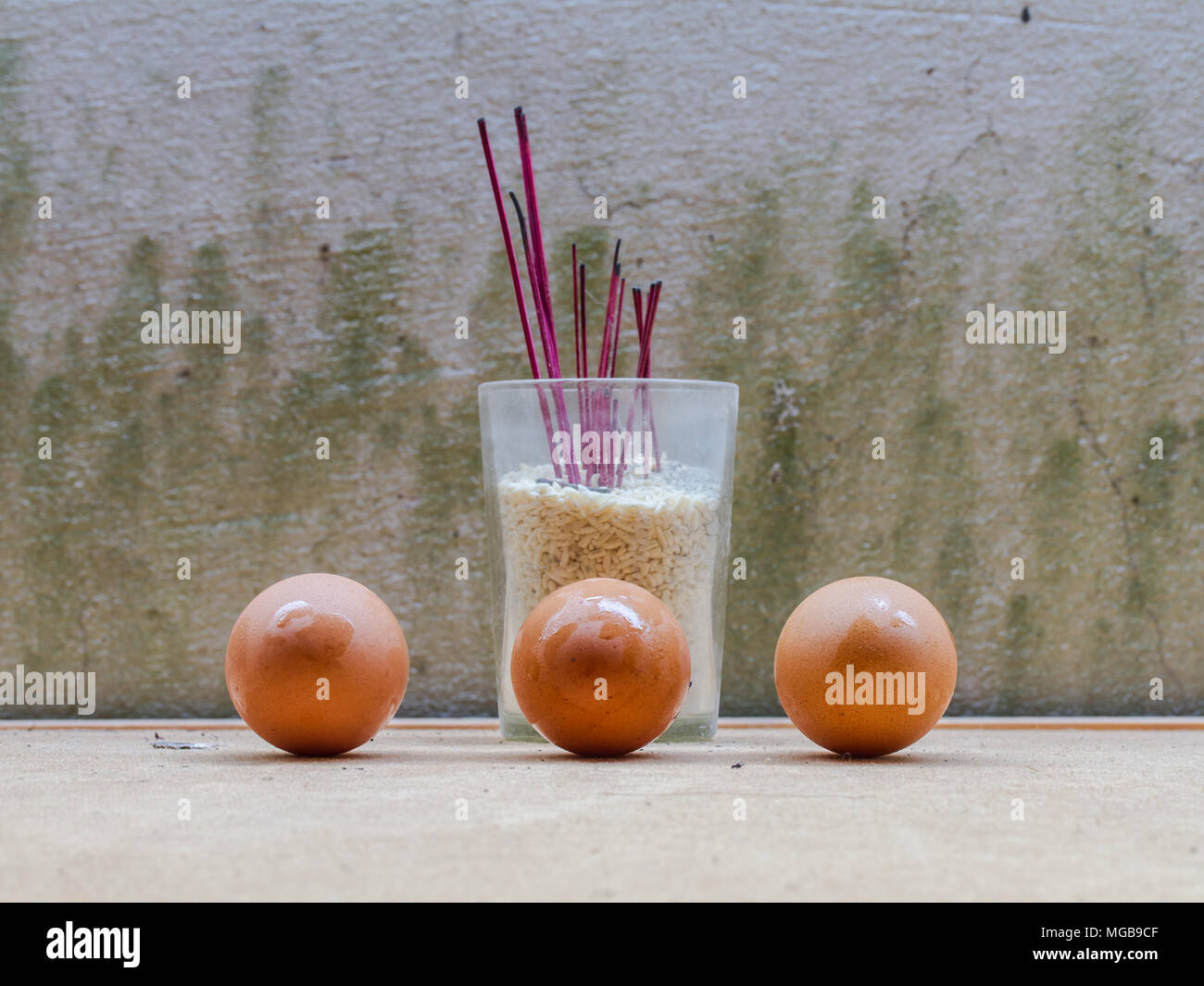 Eggs and incense burner on wall background Stock Photo Alamy