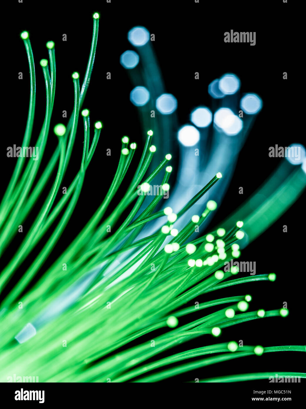 Bundle of optical fibers with green light. Black background Stock Photo