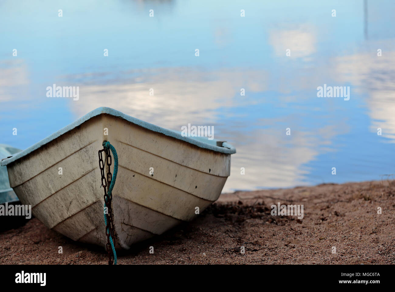 Boat on the shore. Sky reflects on water Stock Photo - Alamy