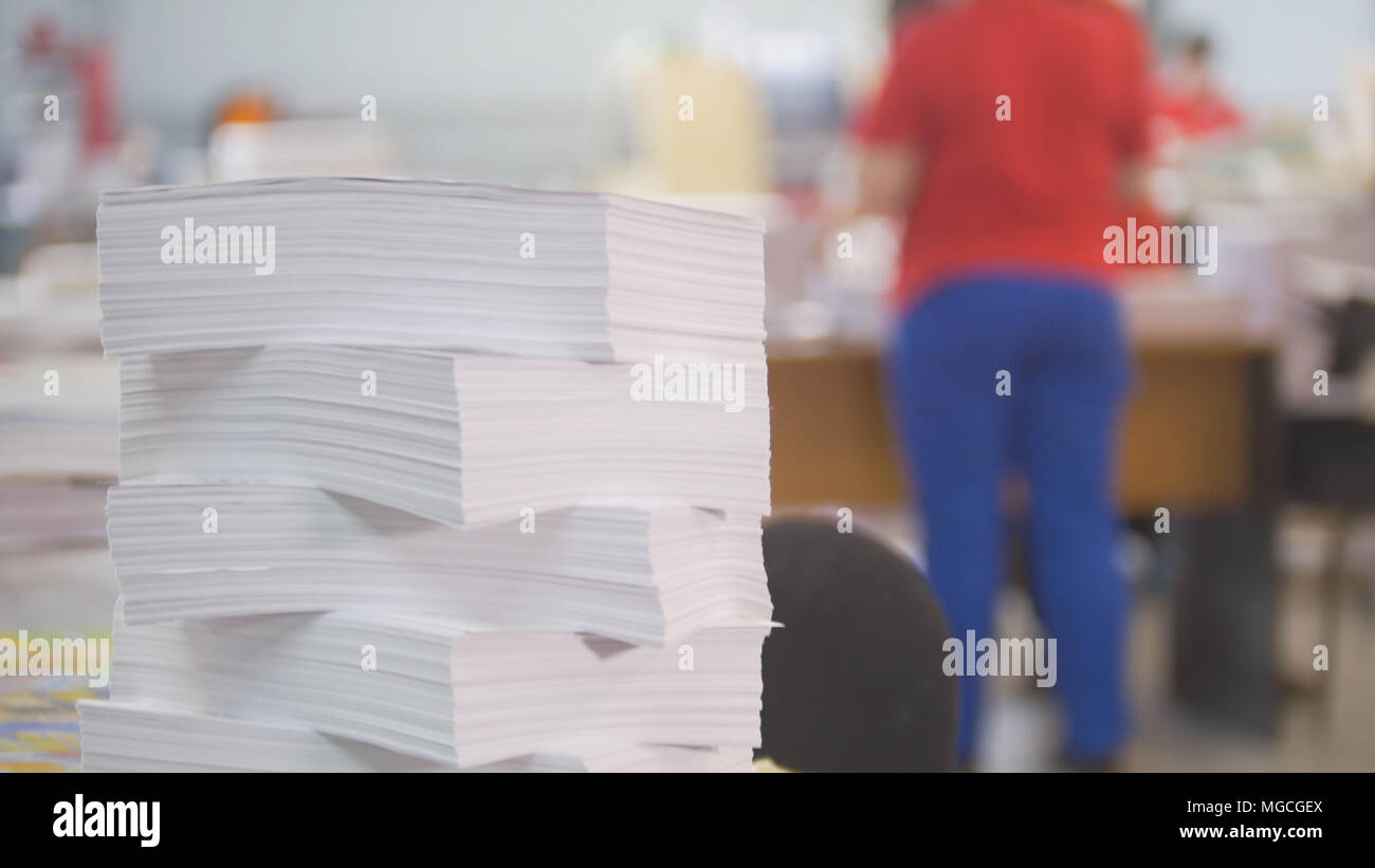 Paper stack in front of worker in the typography Stock Photo - Alamy