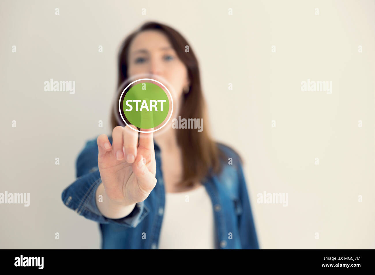 Young woman designer touching virtual button start. New start, beginning, business concept Stock Photo