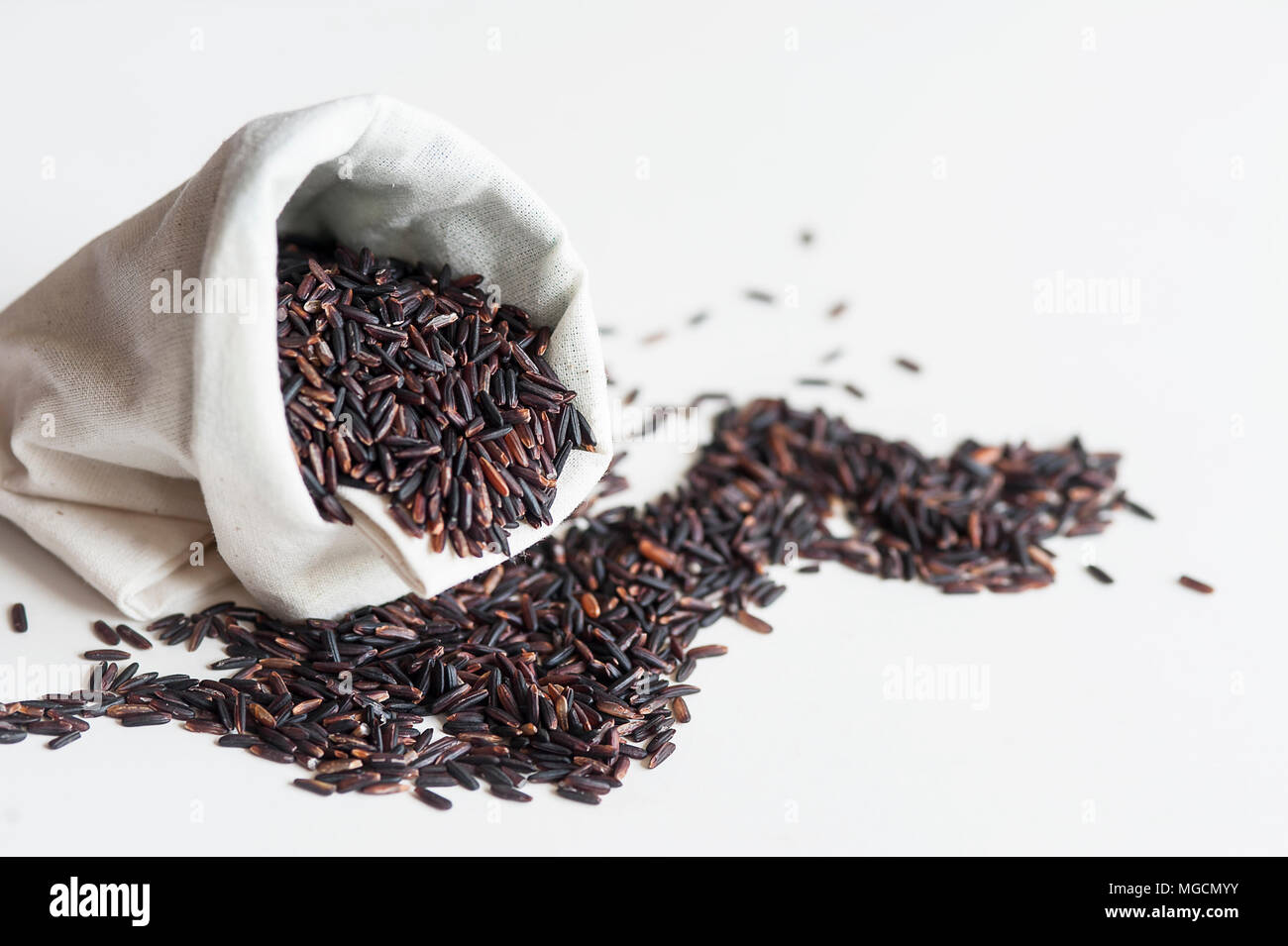 Thai jasmine black rice or rice berry in white sack and pile of heart shape  on white background Stock Photo - Alamy