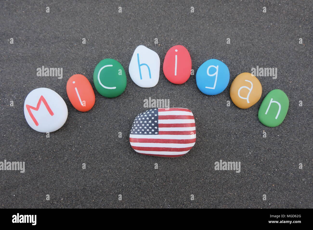 Michigan, United States of America, souvenir with colored stones over black volcanic sand Stock Photo