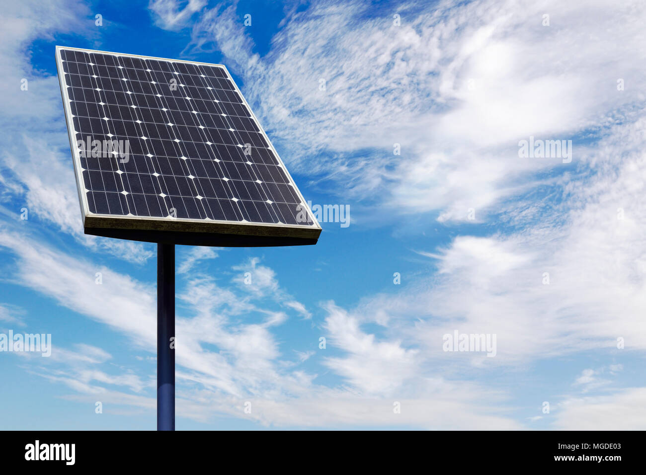 Small Solar Panel Against a Cloudy Blue Sky Stock Photo