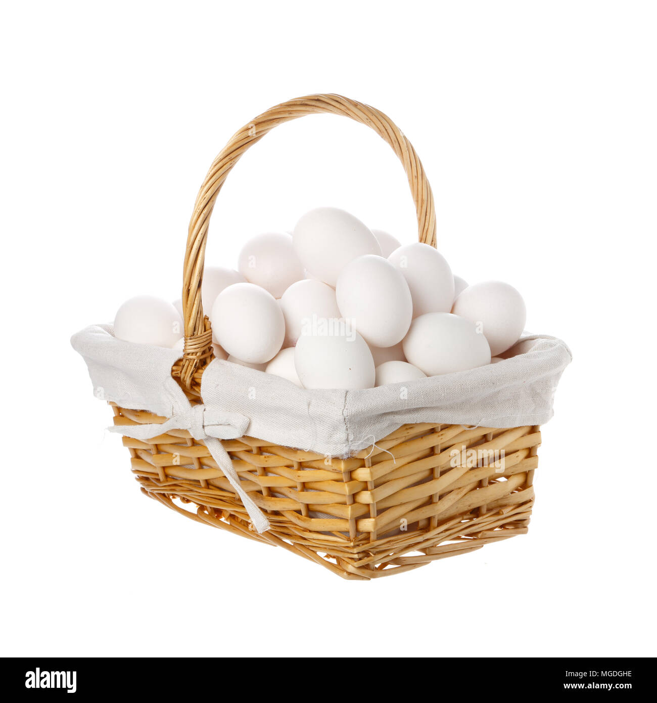A large group of hen eggs collected in a basket with handle isolated on white background. Stock Photo
