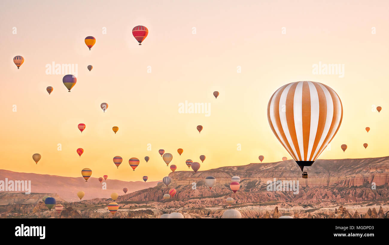 Colorful hot air balloons flying over rock landscape at Cappadocia ...
