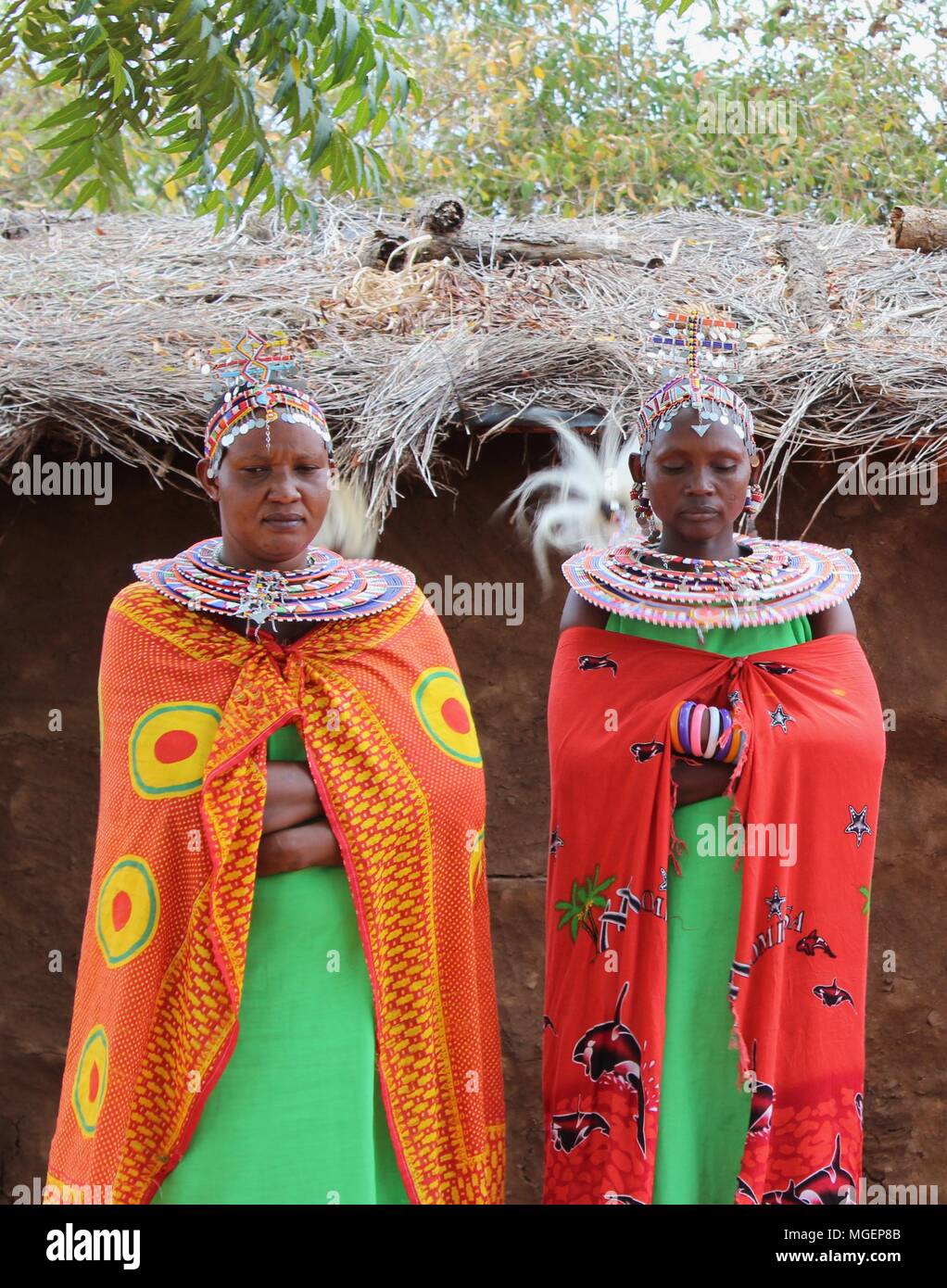 Masai women wearing colorful green and red dresses during a tribal rite in an African village in Kenya, near Nairobi Stock Photo
