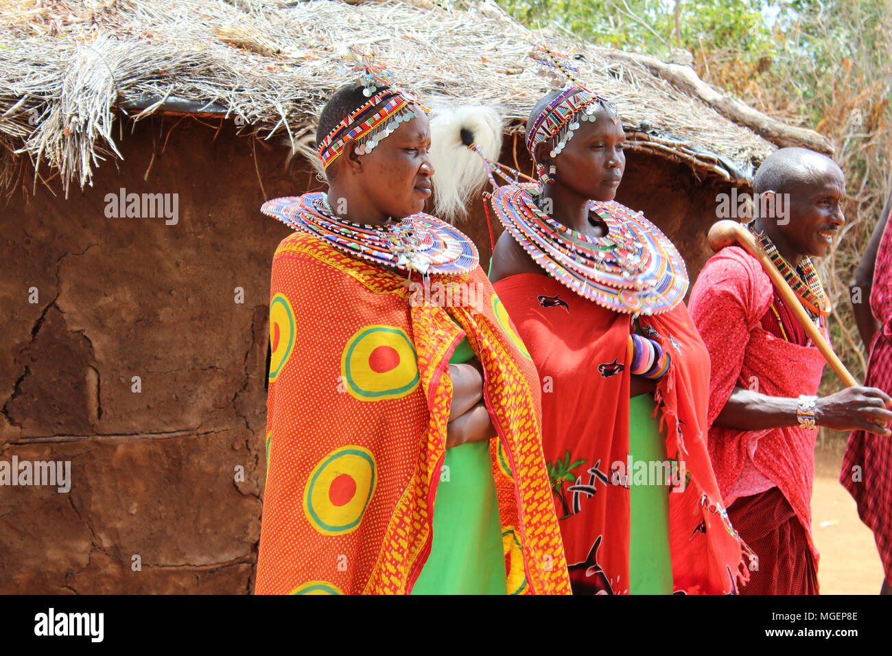 Masai women wearing colorful green and red dresses during a tribal rite in an African village in Kenya, near Nairobi Stock Photo