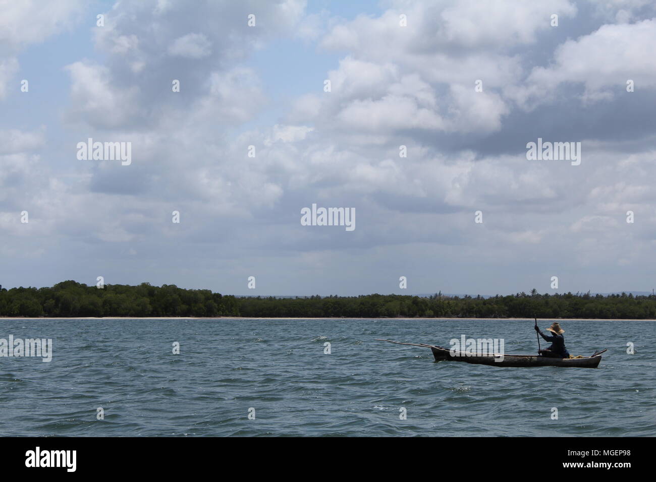 Fisherman sailing on his fishing boat in the middle of the sea looking for fish in Africa Stock Photo