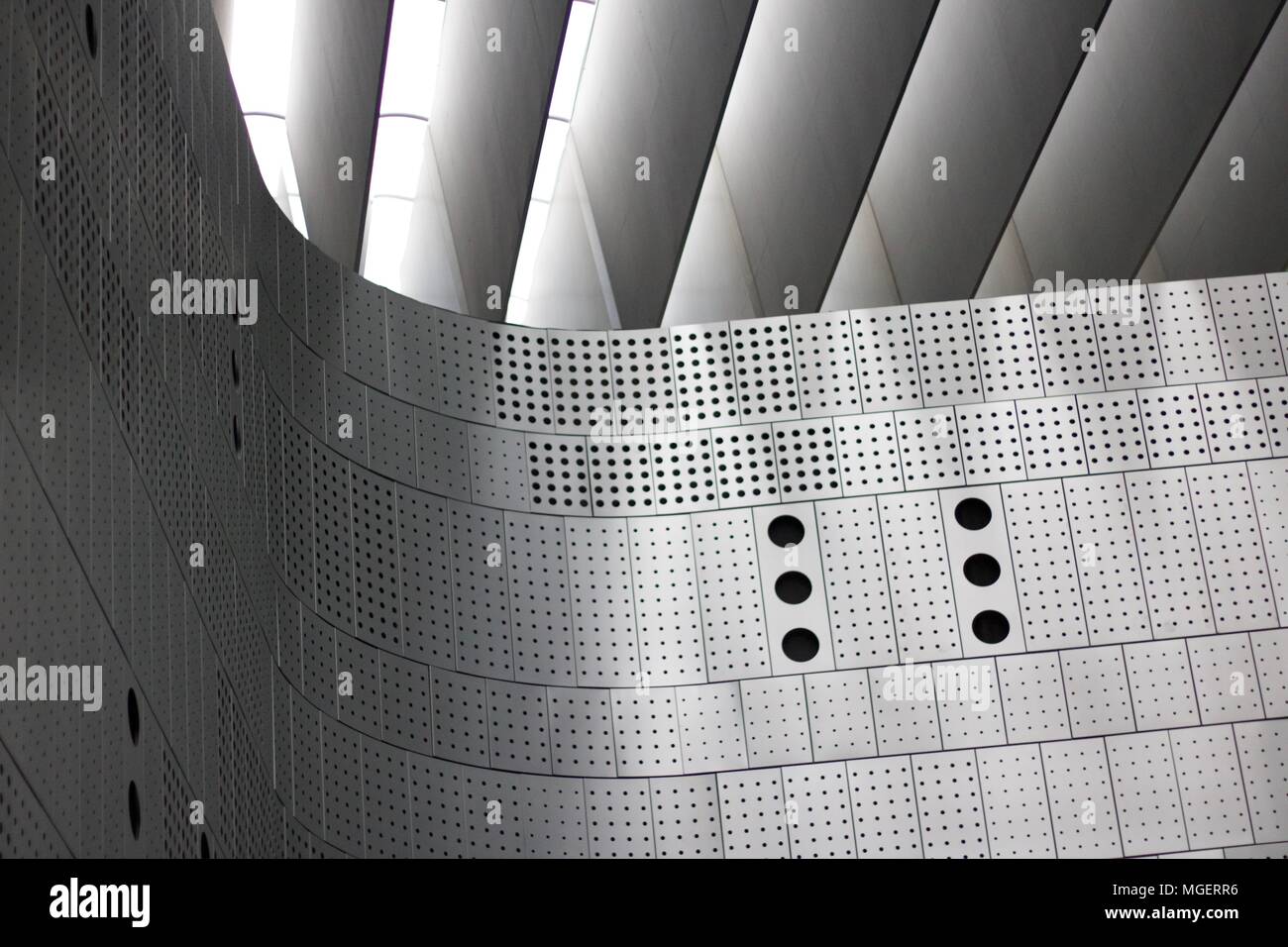 Photograph of a wall made of perforated metal panels with holes of different sizes Stock Photo