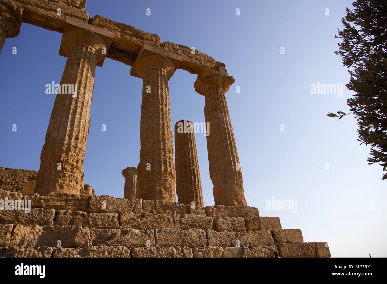 The ruins of a Greek temple with the columns still erected at sunset in ...