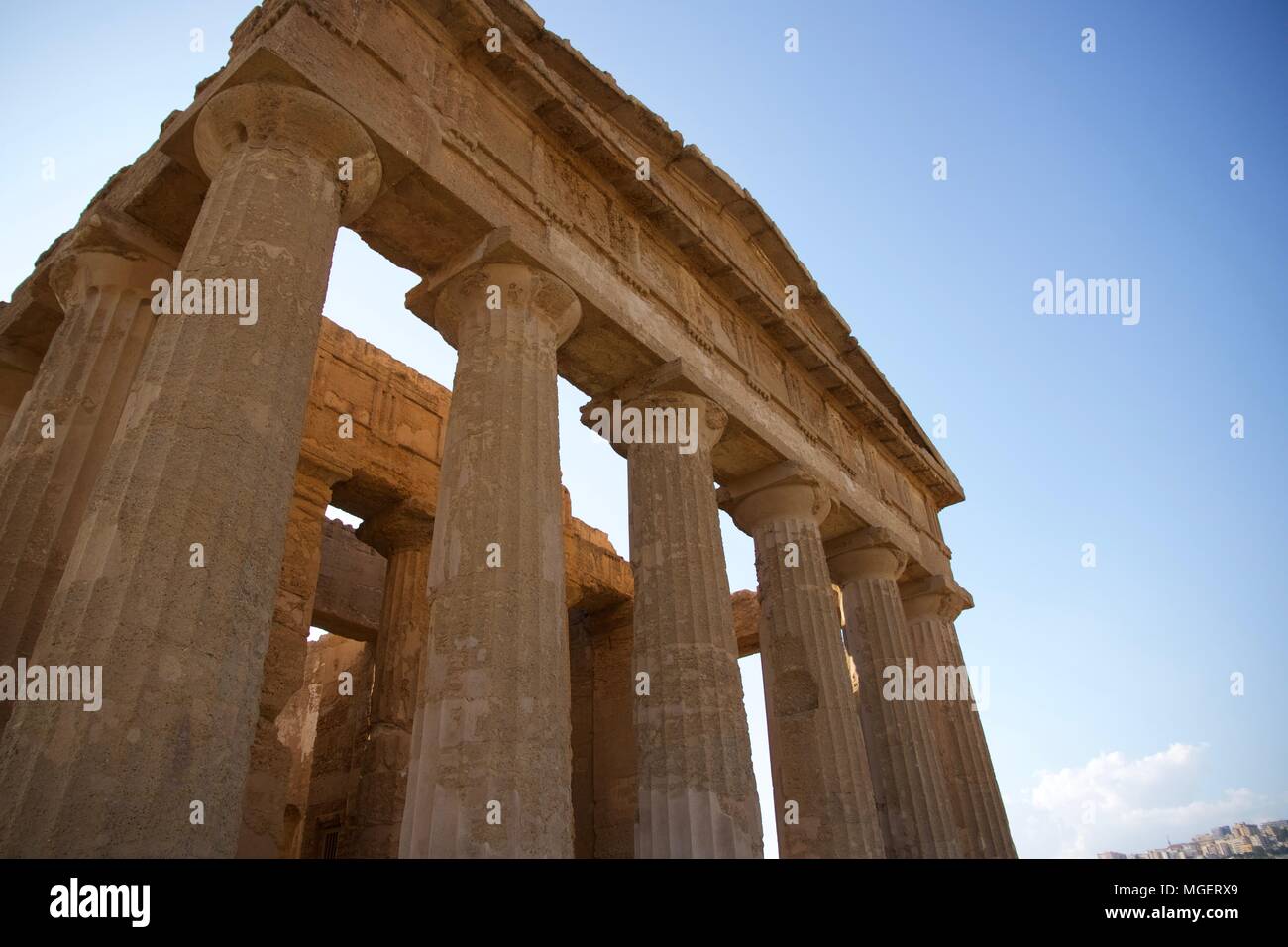 The ruins of a Greek temple with the columns still erected at sunset in ...